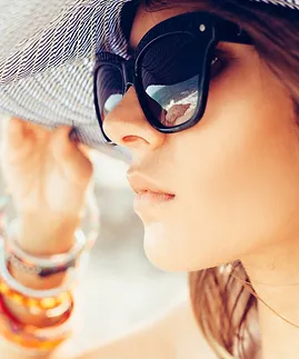 Woman wearing a hat and a pair of large black sunglasses from Mango Optic.