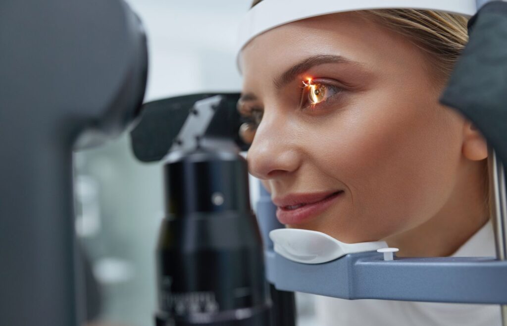 Woman getting her eye exam with a slit lamp.