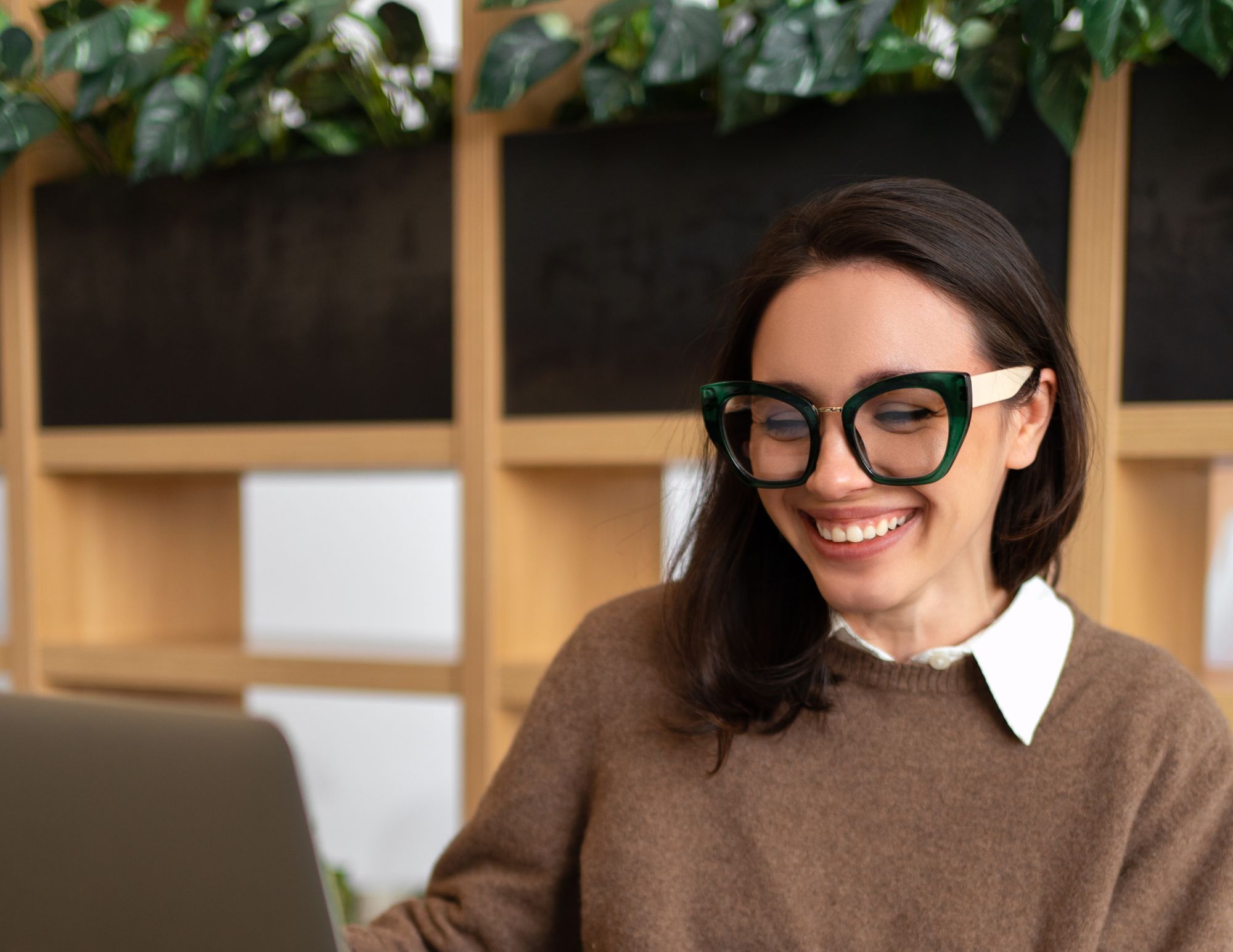 Woman with glasses on her laptop.