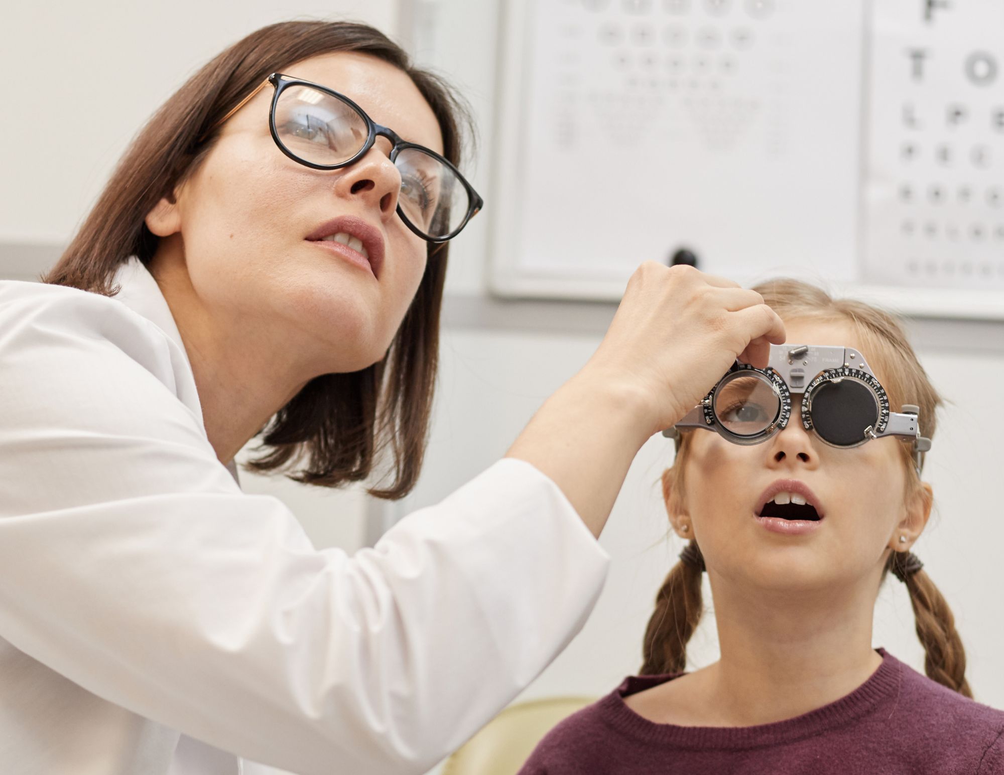 Pediatric eye exam at Mango Optic. Optician checking eyes.
