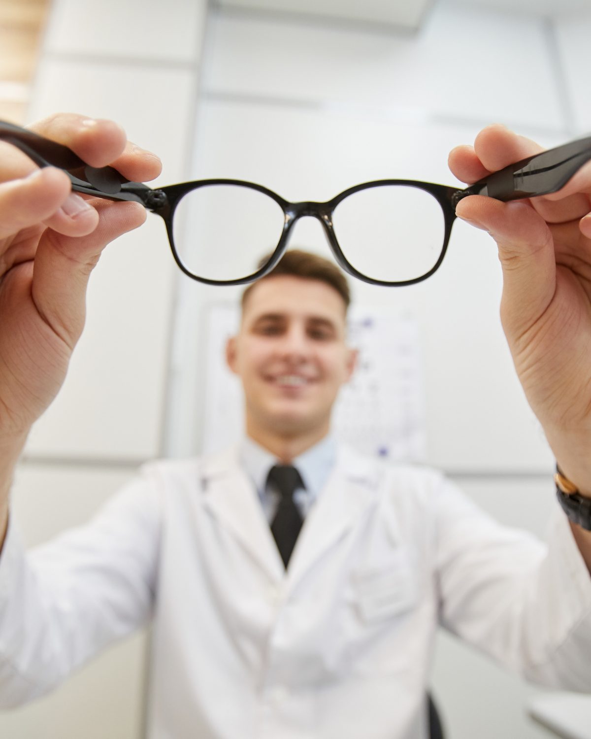Optician performing an eyeglass fitting.